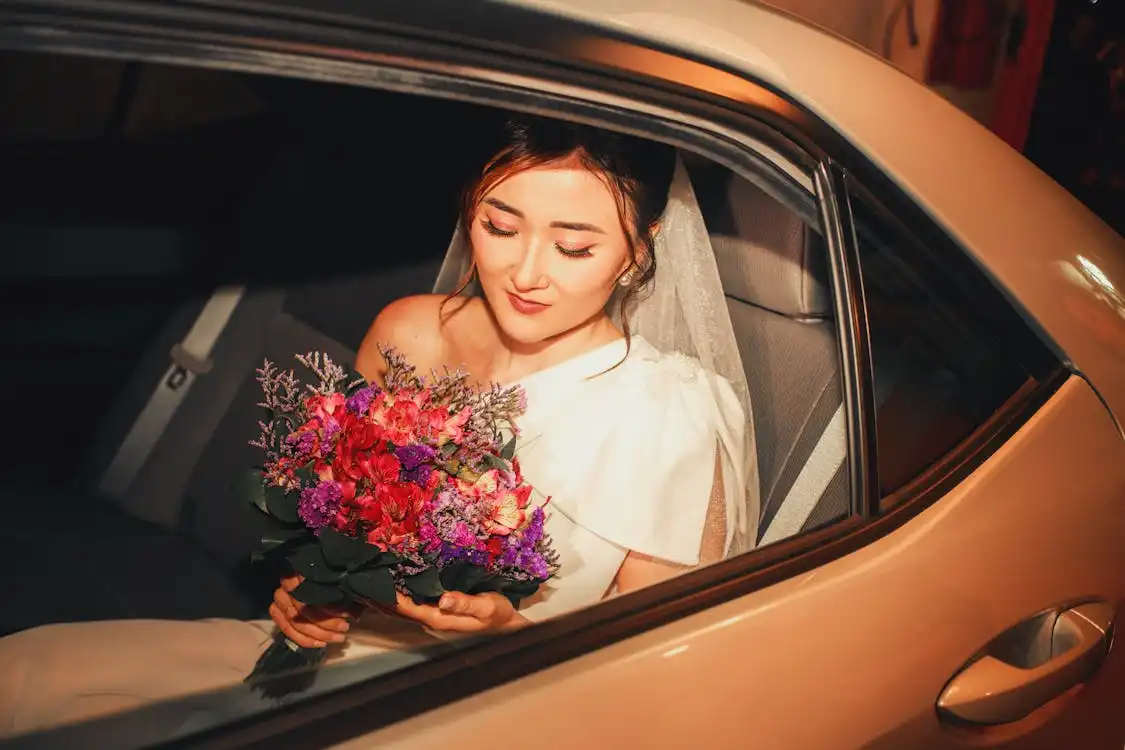 free-photo-of-bride-sitting-in-a-car-with-a-flower-bouquet